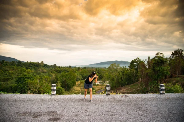 Mulher com câmera digital fotografar fotos em viagem na colina — Fotografia de Stock