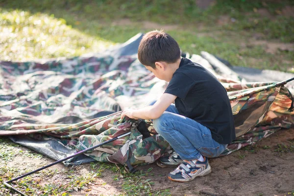 Menino construindo uma barraca para acampar com férias em família horário de verão — Fotografia de Stock