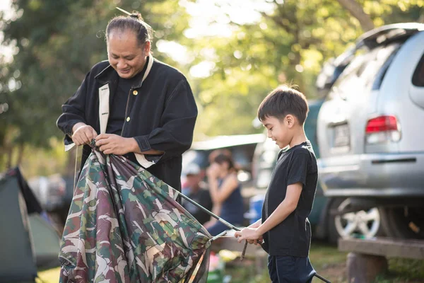 Liten pojke bygga ett tält för camping med familjesemester sommartid — Stockfoto