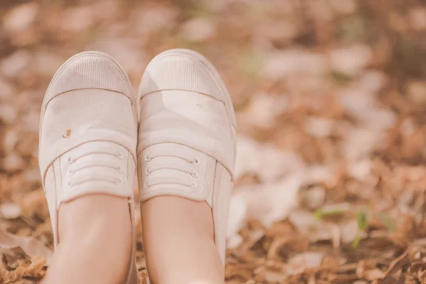 Close-up van vrouw sneaker schoenen in het park zitten terwijl u ontspant — Stockfoto