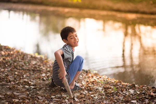 Närbild av asiatiska pojke sitter i th park — Stockfoto