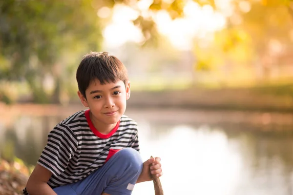 番目の公園に座っているアジアの少年を閉じる — ストック写真