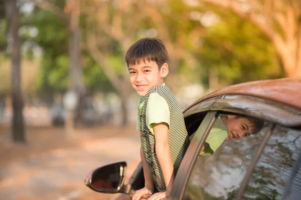 Niño sentado en el coche en el parque —  Fotos de Stock