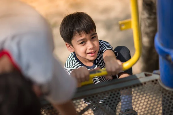 Мальчик играет в ползунок на детской площадке — стоковое фото