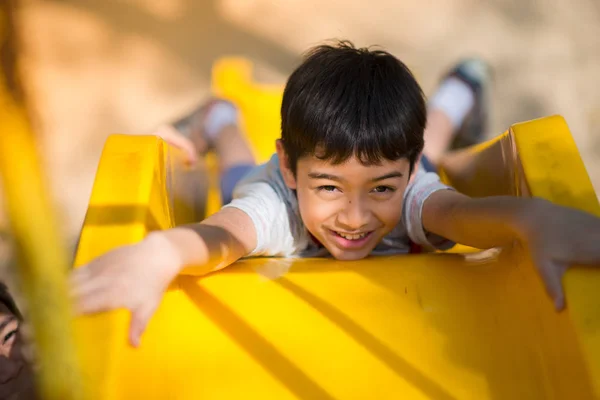 Menino brincando slider no playground — Fotografia de Stock