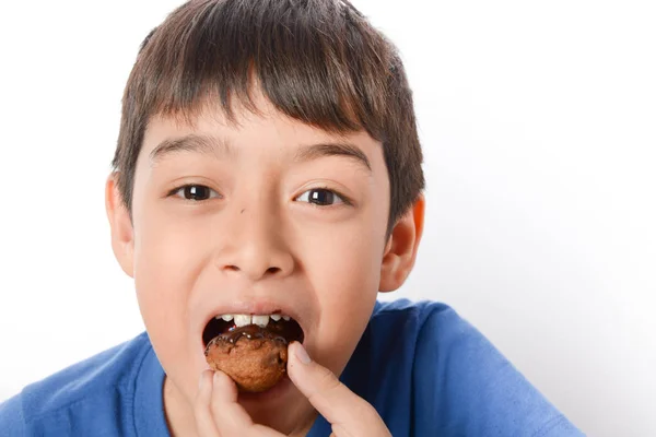 Мальчик готовит и ест шоколадный торт дома — стоковое фото