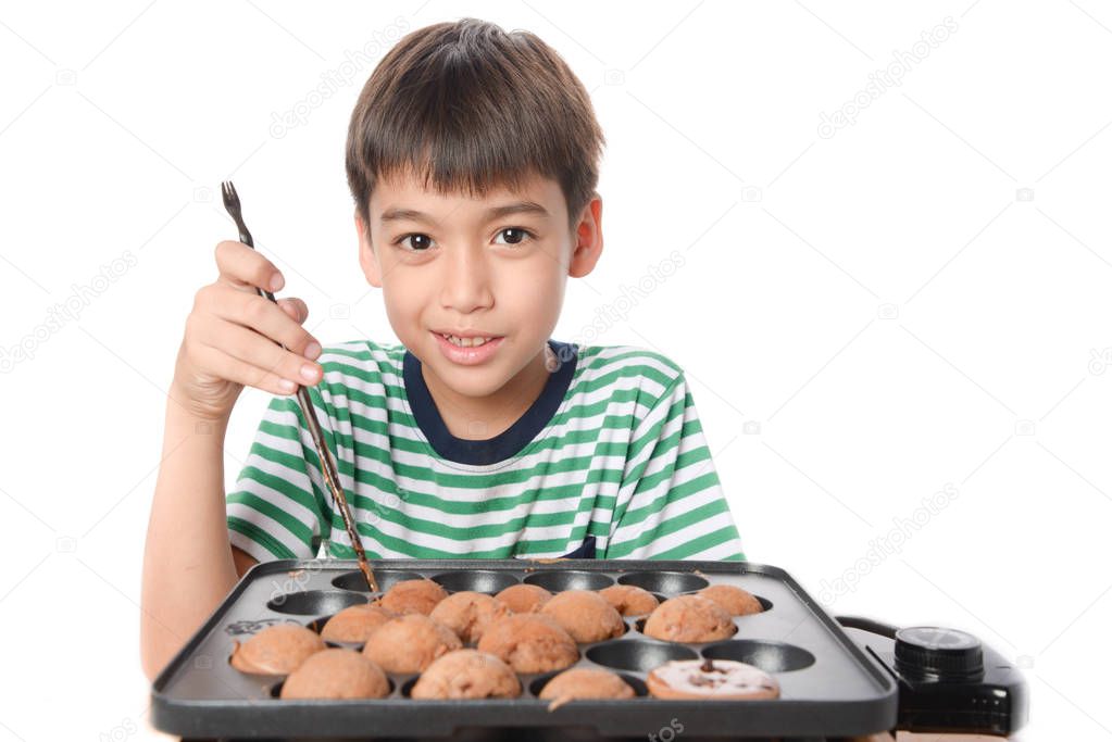 Little boy cooking and eating chocolate cake home made