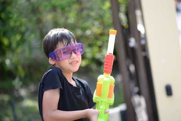 Petit garçon jouant des éclaboussures de pistolet à eau au festival de l'eau de Songkran en Thaïlande — Photo