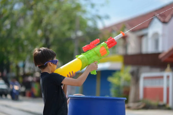 Niño jugando salpicadura de pistola de agua en el festival de agua de Songkran en Tailandia —  Fotos de Stock