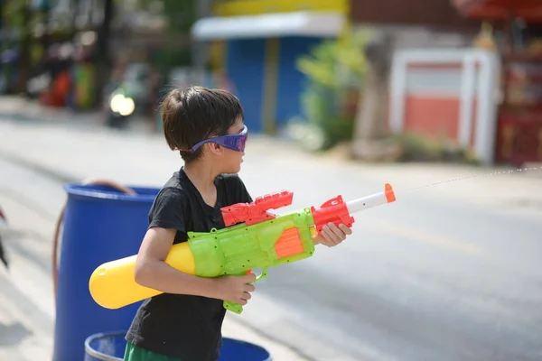 Niño jugando salpicadura de pistola de agua en el festival de agua de Songkran en Tailandia — Foto de Stock