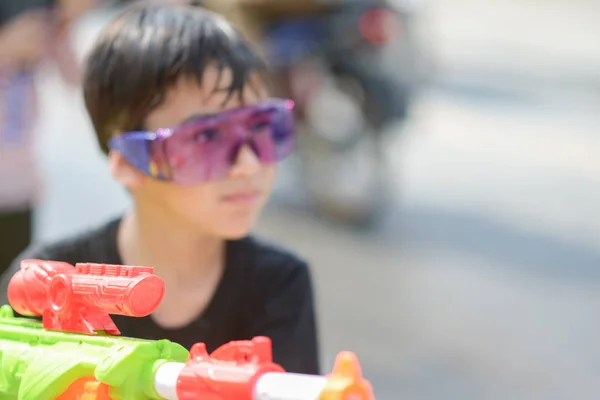 Niño jugando salpicadura de pistola de agua en el festival de agua de Songkran en Tailandia — Foto de Stock
