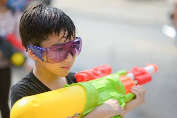 Ragazzino giocare spruzzi d'acqua pistola nel festival dell'acqua di Songkran in Thailandia — Foto Stock