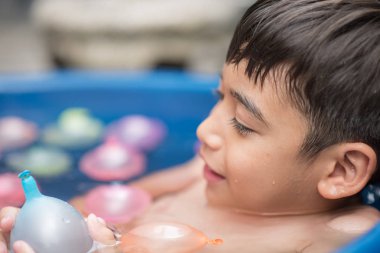 Küçük çocuk su sıçrama gösterilen kabarcık oynamak