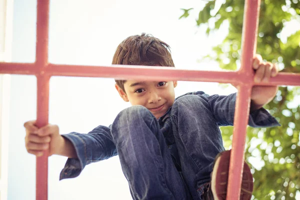 Kleiner Junge klettert auf Spielplatz am Seil — Stockfoto