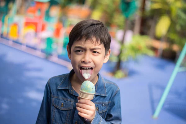 Little boy eating ice cream at playground with happy on summer time — Stock Photo, Image