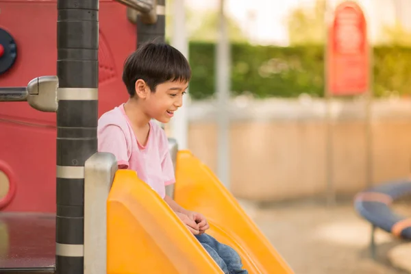 Niños pequeños jugando slider en el patio de recreo — Foto de Stock