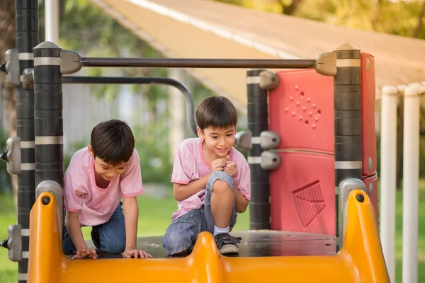 Piccoli ragazzi che giocano slider al parco giochi — Foto Stock