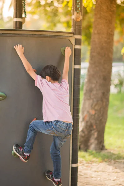 Niño escalando en el patio de recreo — Foto de Stock