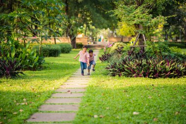 Küçük kardeş Asyalı çocuk birlikte parkta mutlu ile birlikte yaz çalışma süresi