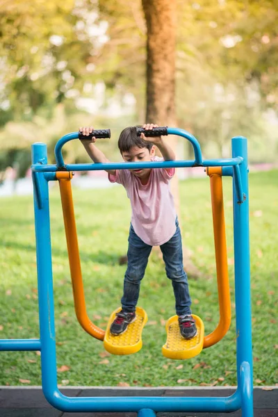 公園で屋外ジムで遊ぶ少年 — ストック写真