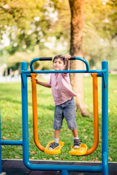 公園で屋外ジムで遊ぶ少年 — ストック写真