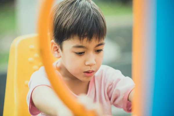 Menino brincando no ginásio ao ar livre no parque — Fotografia de Stock