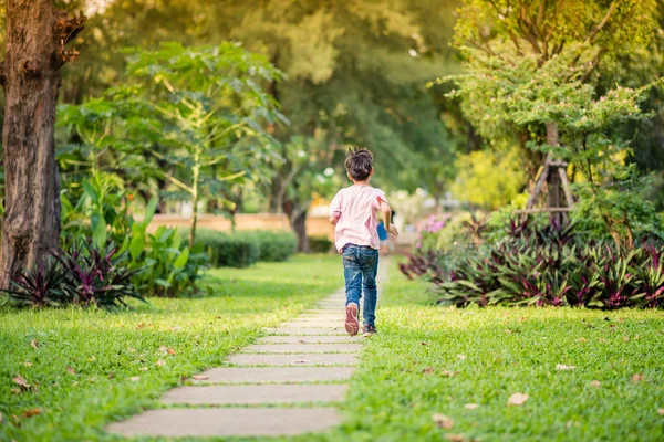 Маленький азиатский мальчик, бегающий вместе в парке с счастливым летним временем — стоковое фото