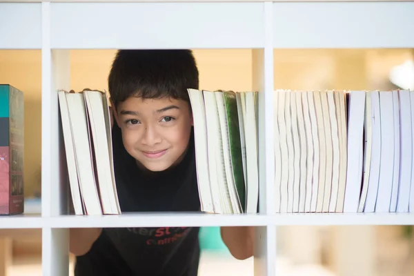 Liten Pojke Biblioteket Skolan Visar Ansiktet Mellan Böcker — Stockfoto