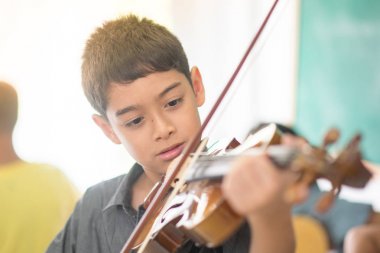 Küçük çocuklar oynamak ve müzik sınıfı odasında keman uygulama