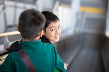 Küçük çocuk elektrikli bilet alıyor ve aile ile birlikte gökyüzü tren istasyonunda yürüyor. 