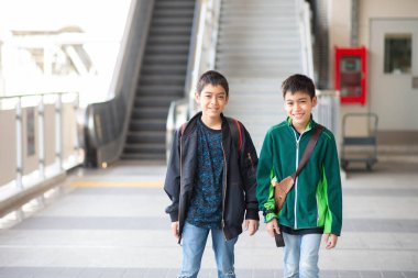 Küçük çocuk elektrikli bilet alıyor ve aile ile birlikte gökyüzü tren istasyonunda yürüyor. 
