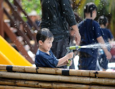 Çocuklar dışarıda su sıçratır eğlence ve ıslaklık ile