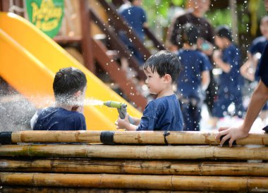 Çocuklar dışarıda su sıçratır eğlence ve ıslaklık ile