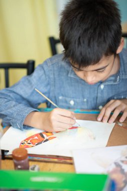 Kid learning art painting and crafting in the art classroom 