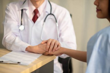 Asyalı doktor ve hasta hastanede sağlık sigortası hastalığını konuşuyor ve kontrol ediyor.