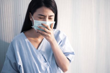 Maske takan Asyalı hasta kadın virüsü hastanedeki hastalıklardan koruyor.