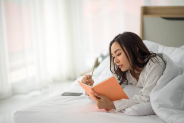 Asyalı kadın evdeki defter işlerini kullanıyor 