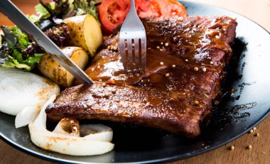 Tabağında barbekü sosu olan domuz pirzolası ızgara. 