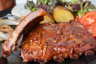 Tabağında barbekü sosu olan domuz pirzolası ızgara. 