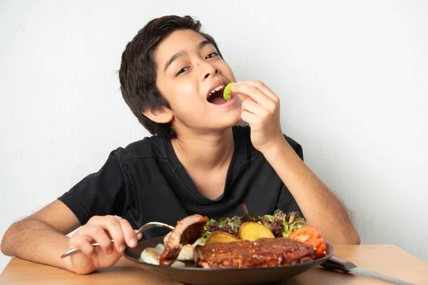 Kleine Jongen Eet Rib Varkensvlees Grill Met Gelukkig Gezicht Stockfoto