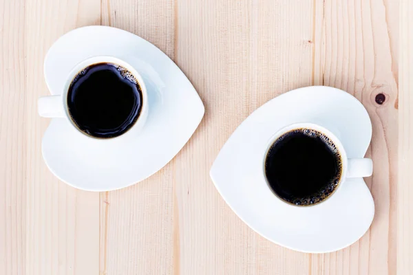 Twee witte koffiekopje op houten tafel — Stockfoto