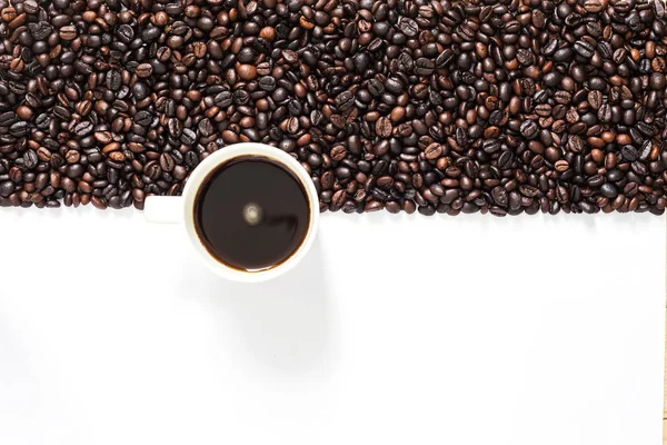 Granos de café sobre fondo blanco en medio marco con café blanco —  Fotos de Stock