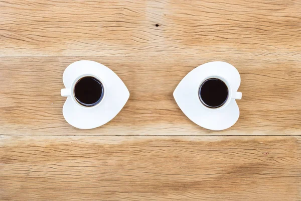 Dos tazas de café con platillo en forma de corazón sobre fondo de madera —  Fotos de Stock