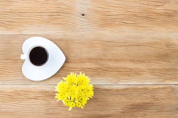 Koffiekopje en hart vormig schotel op houten achtergrond — Stockfoto