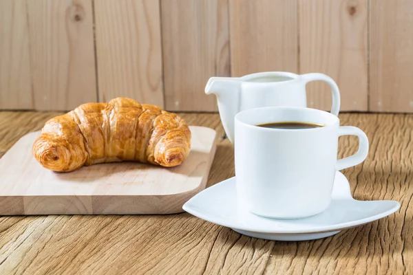 kahve fincanı ve kruvasan ahşap masada