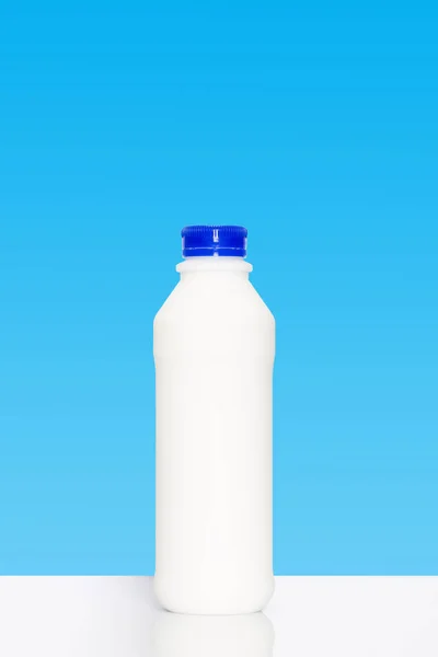 Bouteille de lait sur fond bleu — Photo