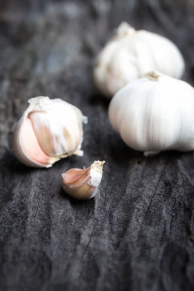 Garlic on dark wooden floor — Stock Photo, Image