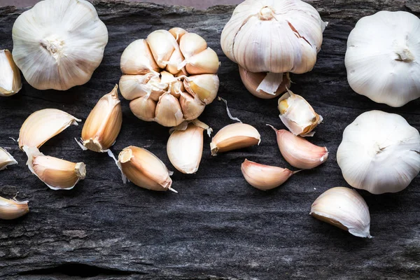 Garlic on dark wooden floor — Stock Photo, Image