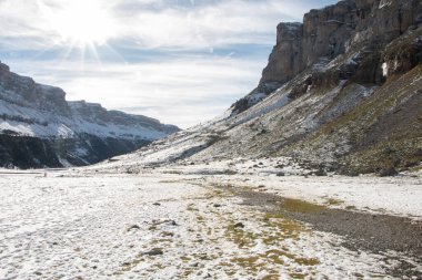 Güneşli dağların arasında karla kaplı bir geçit..