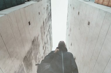 Genç adam karanlık şehirde yalnız yürüyor ve geleceğe bakıyor.